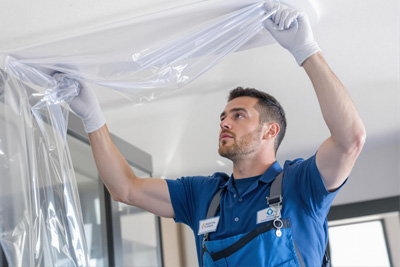 man removing protective plastic sheet from a fixture