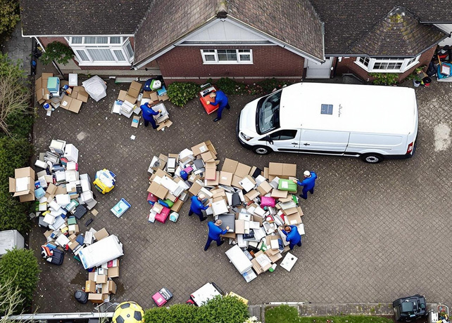 team of clearance specialists sorting items in courtyard in a hoarding case